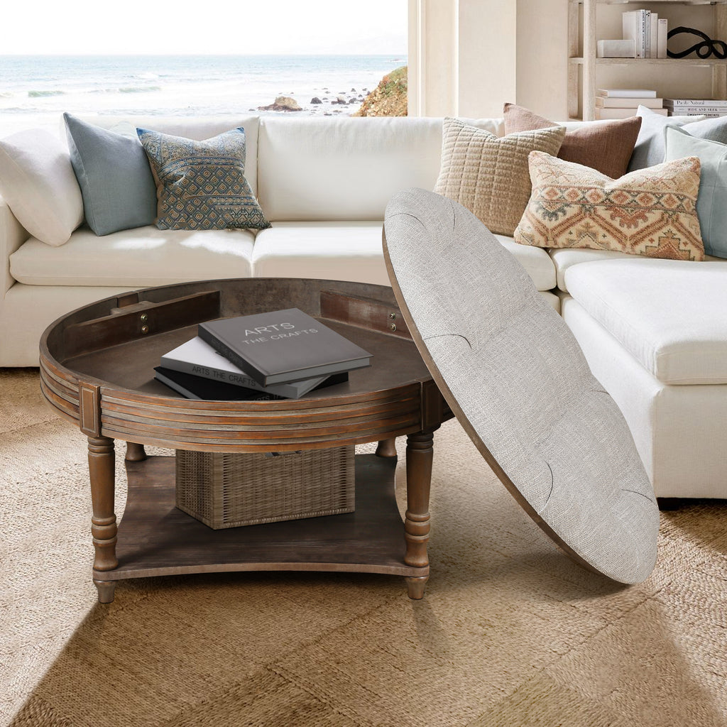 Living room with a white sectional sofa, round wooden coffee table, and decorative pillows.