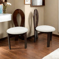 Two wooden chairs with white cushioned seats in a room setting.