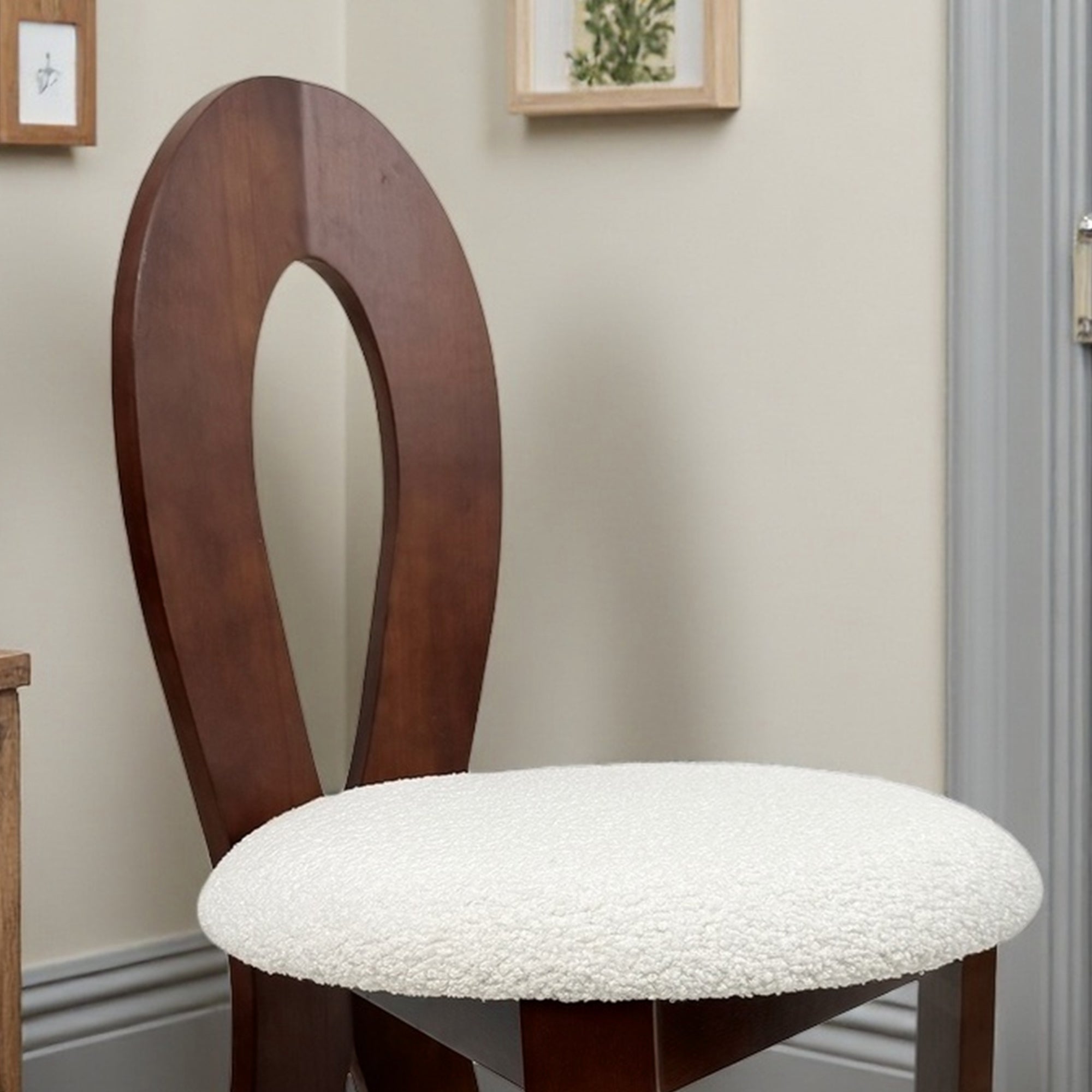 Wooden chair with a white cushioned seat in a room setting.