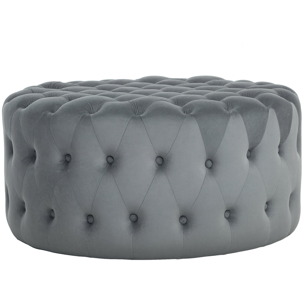 Gray tufted ottoman on a white background