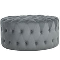 Gray tufted ottoman on a white background