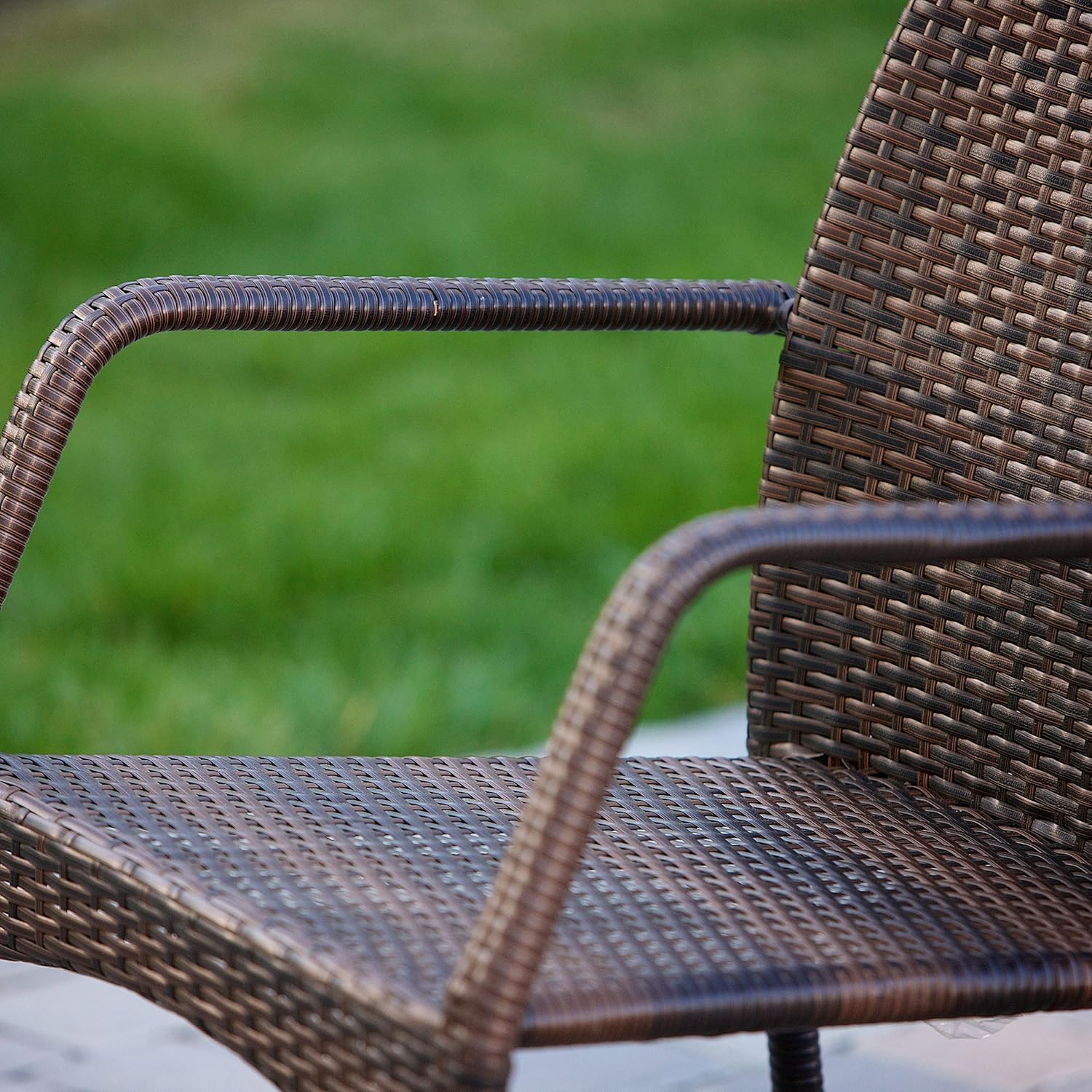 Brown wicker chair with blurred green grass in the background