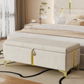 Beige storage bench in front of a bed in a bedroom setting