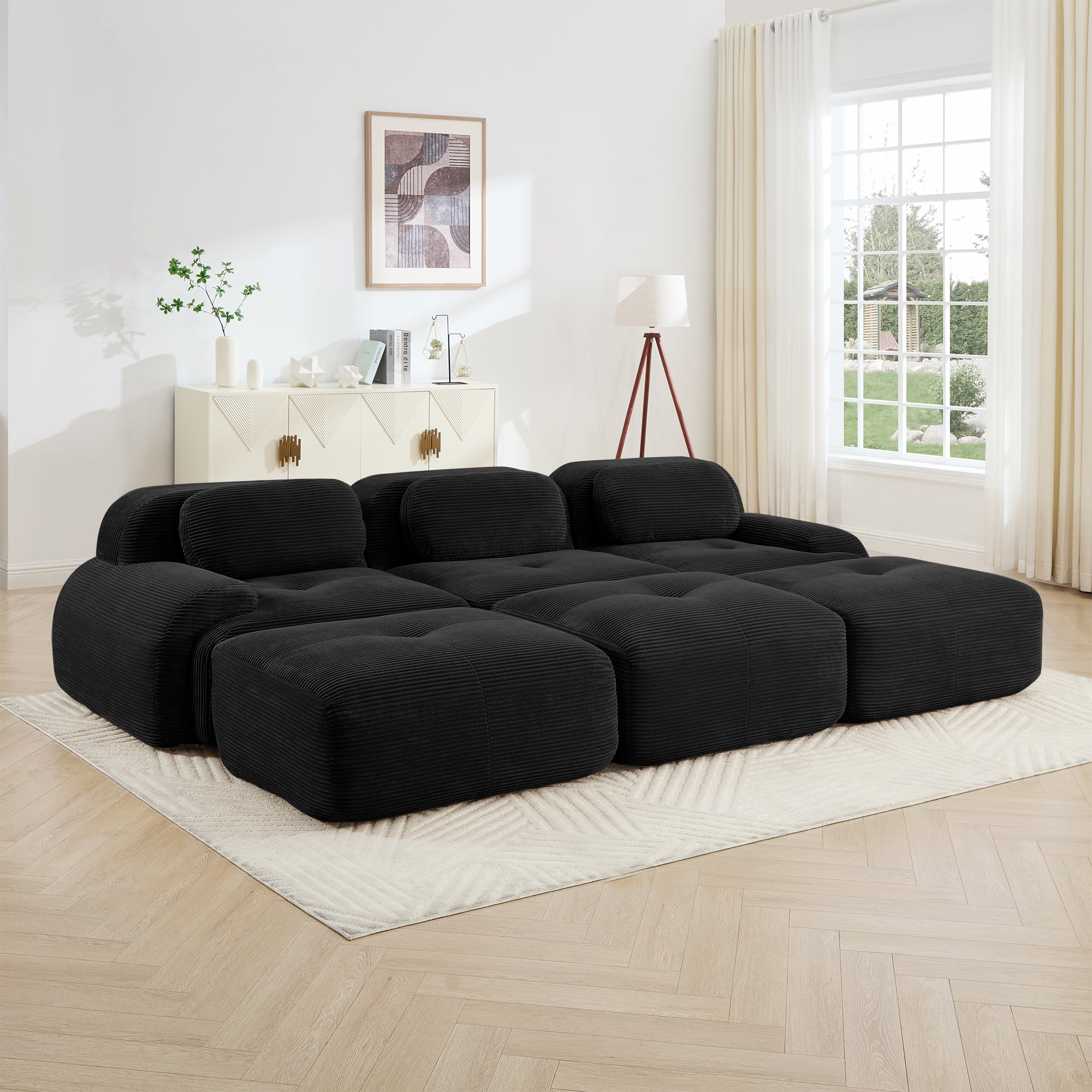 Black sectional sofa in a living room with a white wall and window.