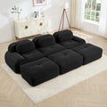 Black sectional sofa in a living room setting with a rug and decor.