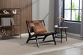Modern living room with a brown and black chair, side table, and bookshelf.